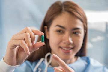 Woman hand holding a pills take medicine according to the doctor's order