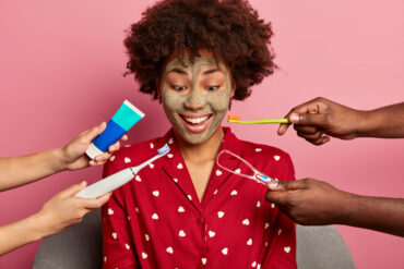 Dark skinned woman gets dental treatment, cares about teeth, wears red pajama