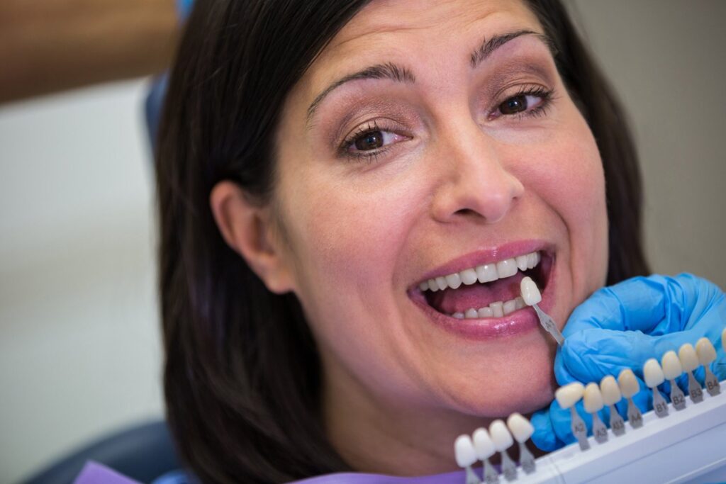Dentist examining female patient with dental veneers