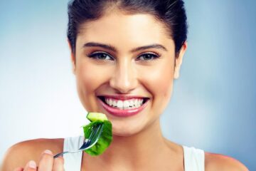 Woman portrait and happy salad and vegetable for health and nutritionist in isolated blue background vegan face and wellness diet with female model in studio and organic food for oral care